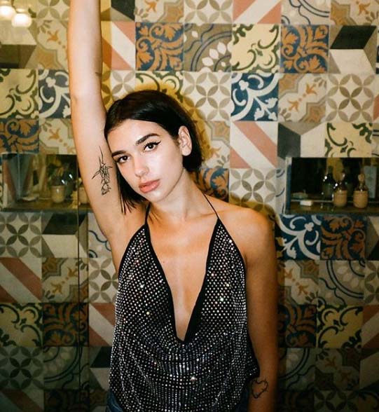 Dua Lipa showing her tattoo.